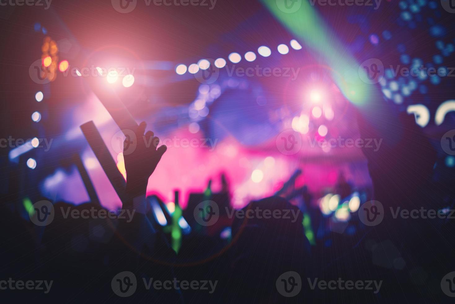 siluetas de multitud de personas en concierto luces brillantes del escenario foto
