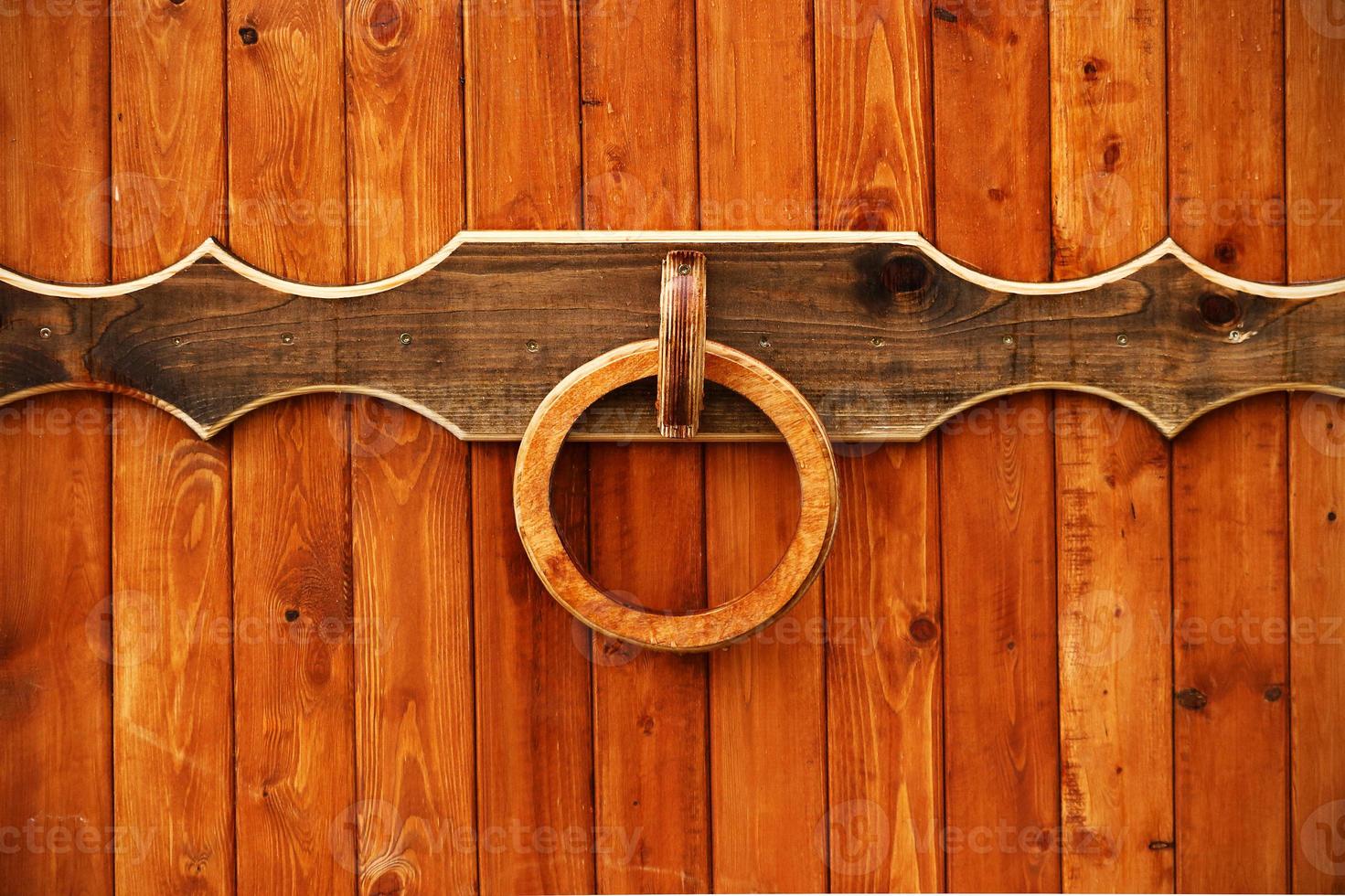 Wooden entrance gate with round knocker handle photo