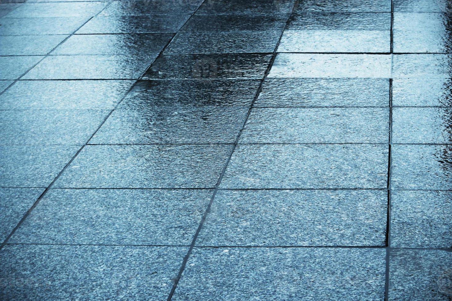 Blue wet tiled shiny pavement with reflections photo