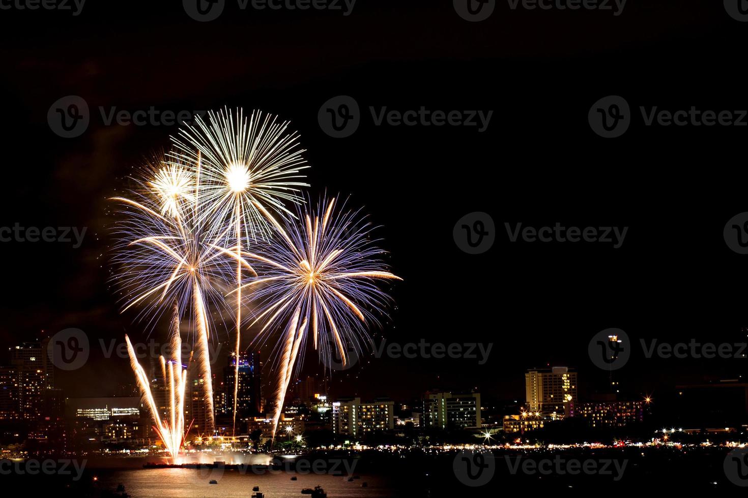 muchos fuegos artificiales destellantes con fondo de paisaje nocturno celebran el año nuevo. foto