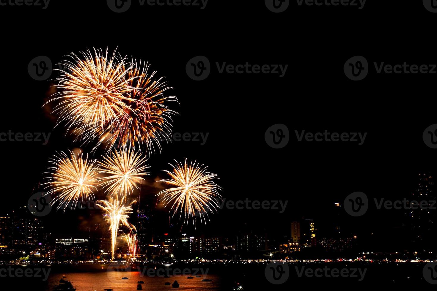 muchos fuegos artificiales destellantes con fondo de paisaje nocturno celebran el año nuevo. foto