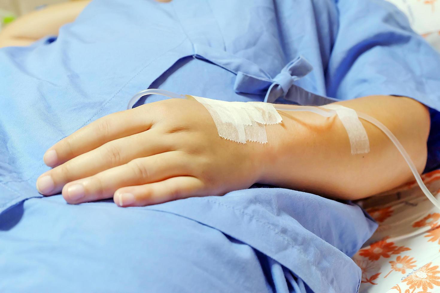 Saline intravenous drip in a women patient hand photo