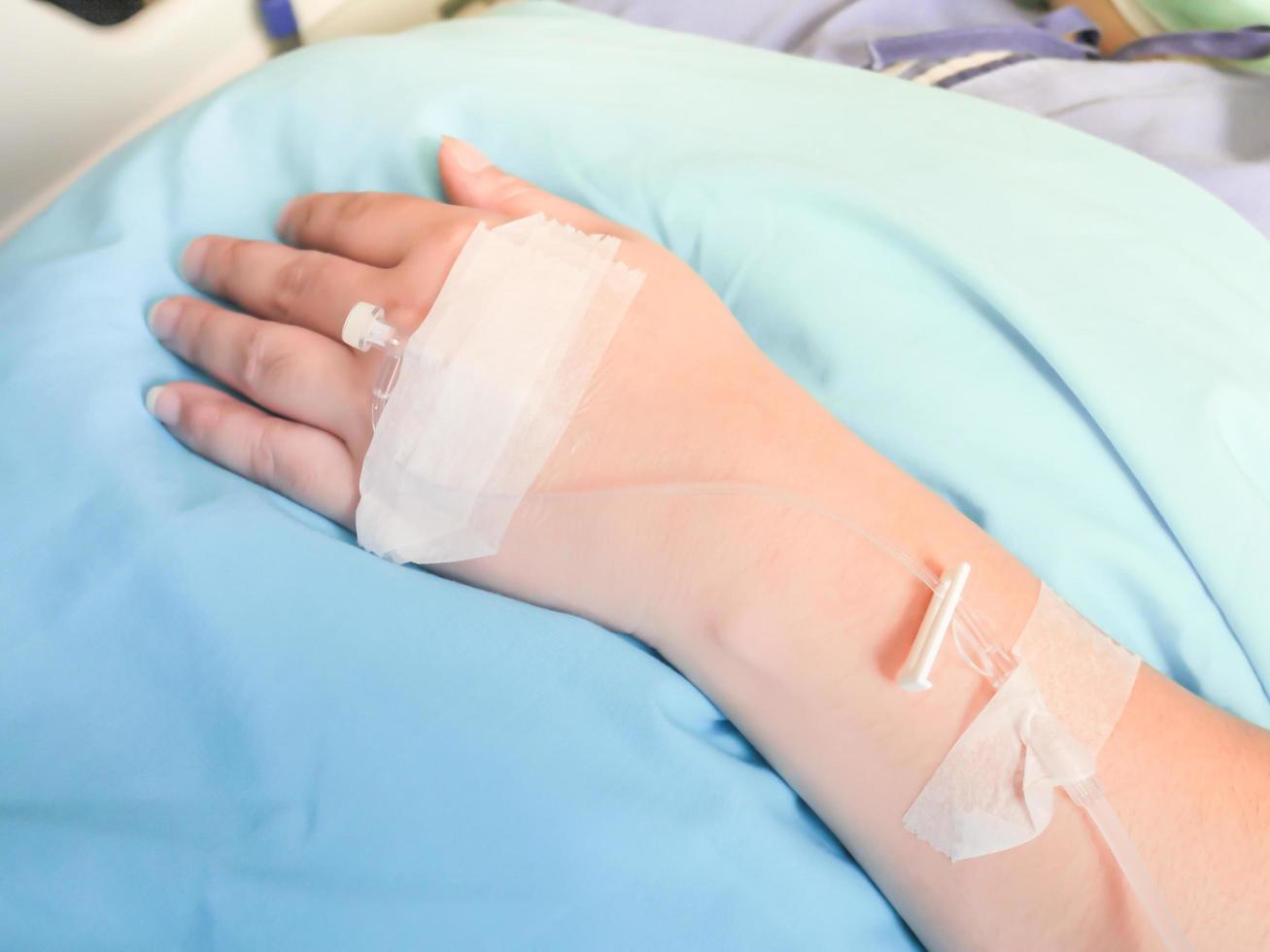 paciente en el hospital con solución salina intravenosa iv, solución salina en el cuerpo para tratamiento foto