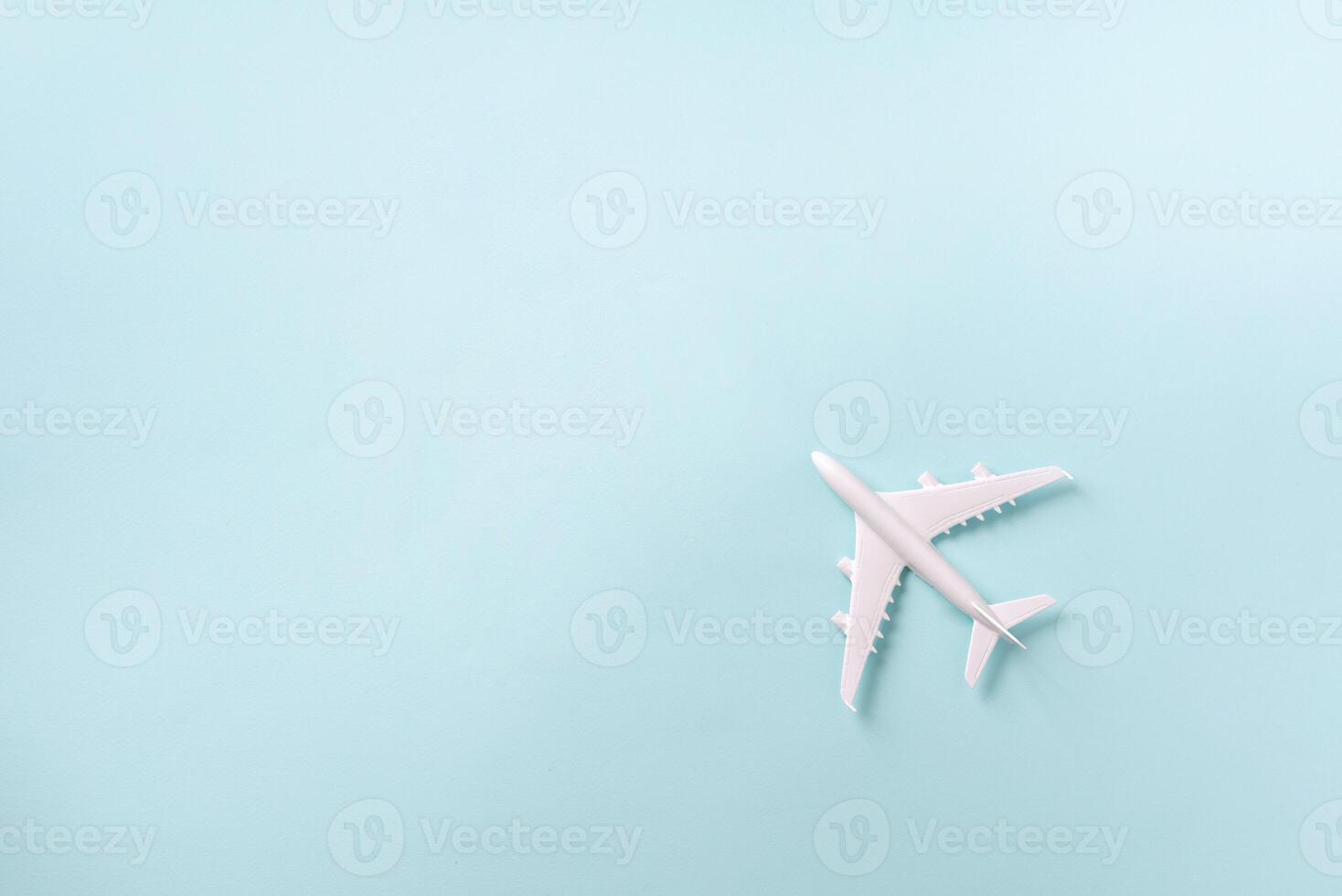 avión blanco, avión sobre fondo de color azul pastel con espacio de copia. vista superior, endecha plana. diseño de estilo minimalista. viajes, concepto de vacaciones foto