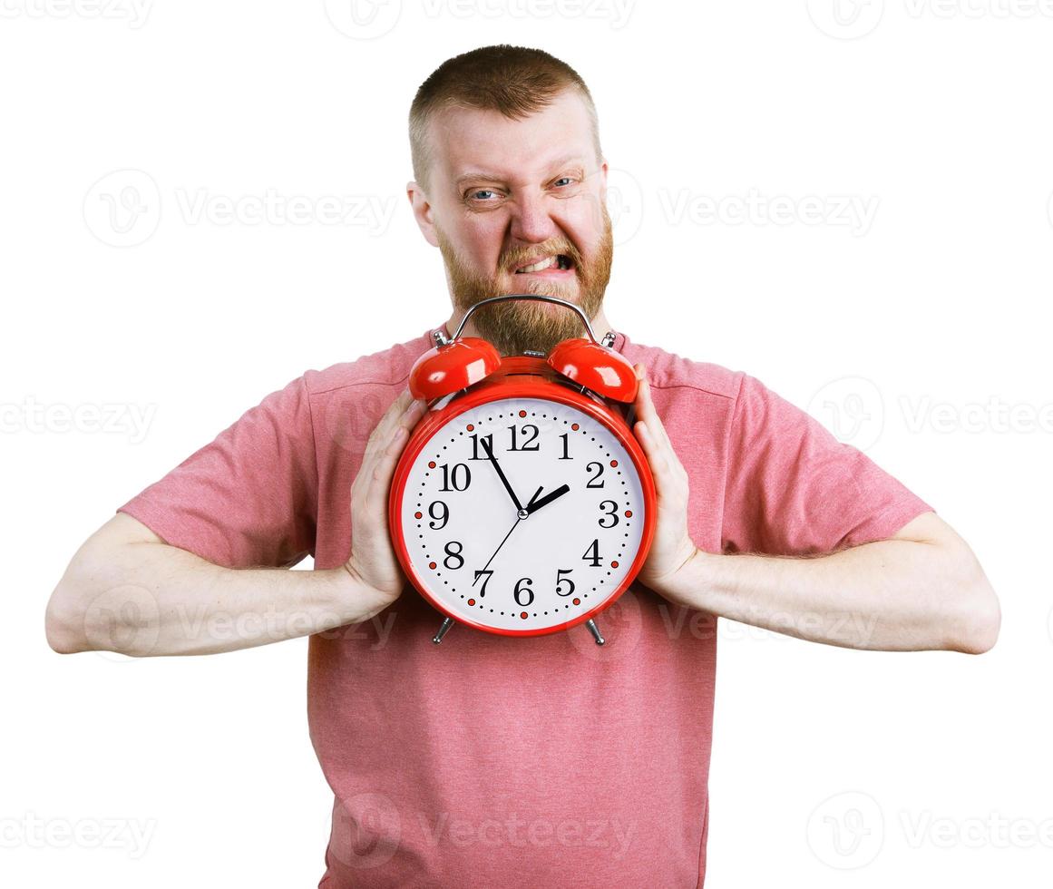 Man trying to break a big alarm clock photo