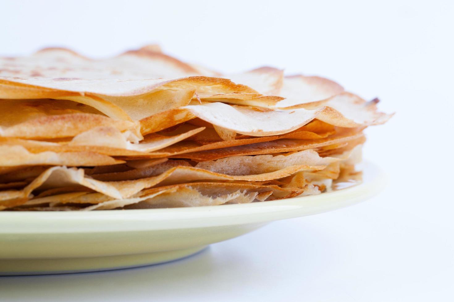 Stack of pancakes lies on the ceramic plate photo