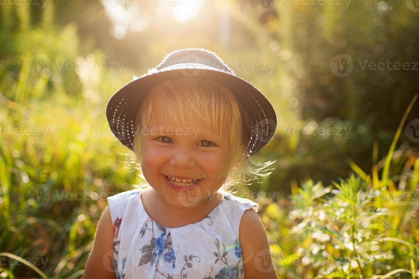 Little blonde girl in a blue hat photo