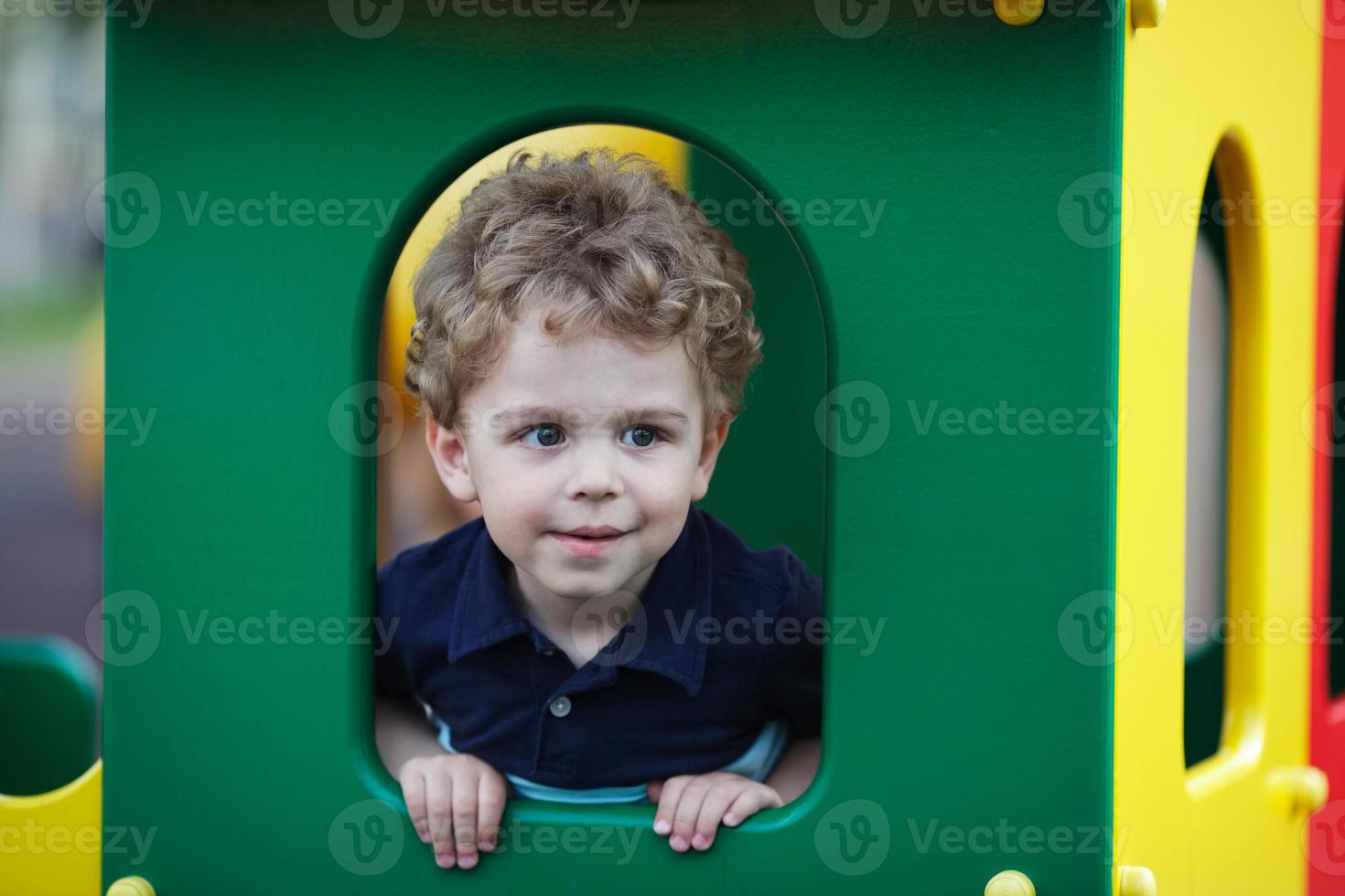 Little boy hiding in a playhouse photo