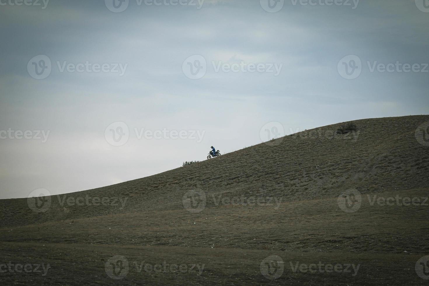 The biker rides motorcycle on mountains photo