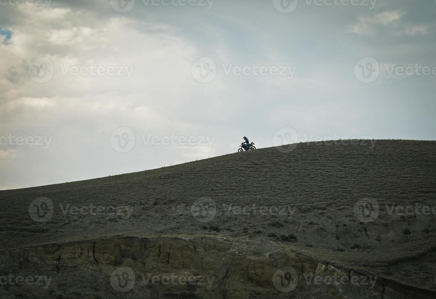 The biker rides motorcycle on mountains photo