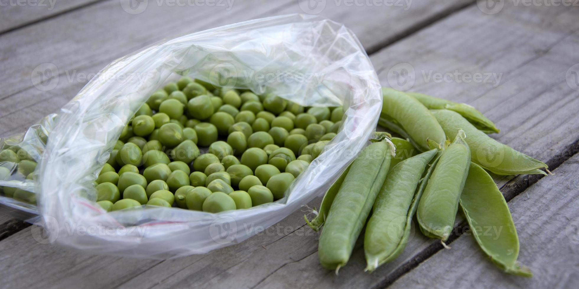 Green peas lie on a wooden background. Harvesting fresh vegetables from the garden. photo