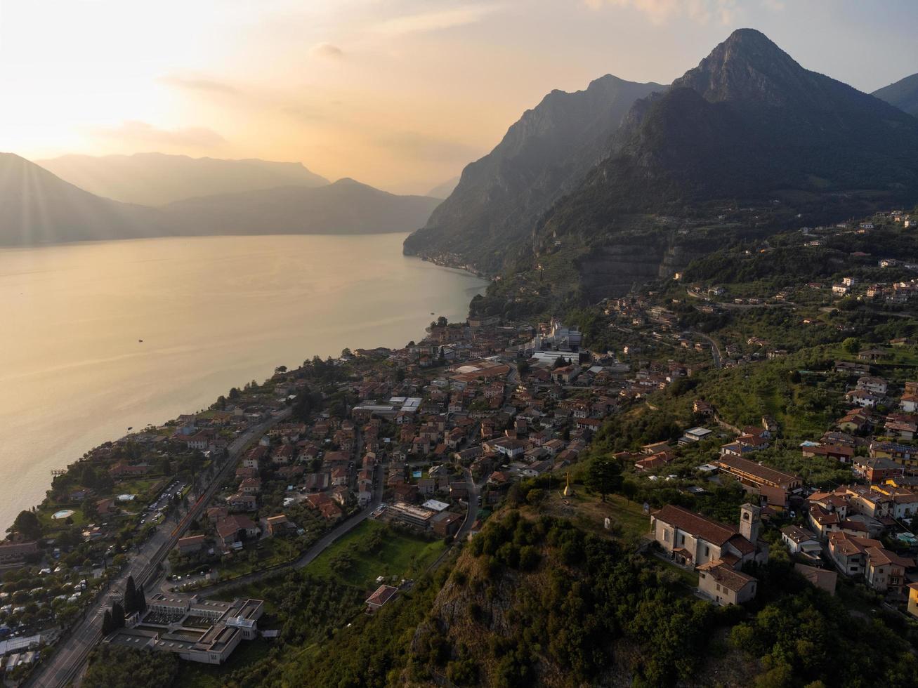 Vista aérea de un pequeño pueblo con vistas al lago al atardecer foto