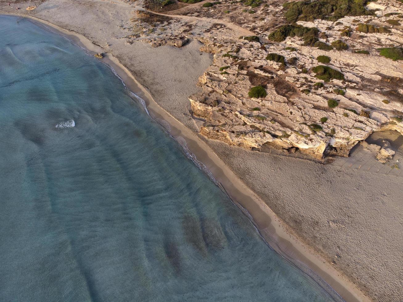 Vista aérea de las olas del mar azul y la playa de arena. foto