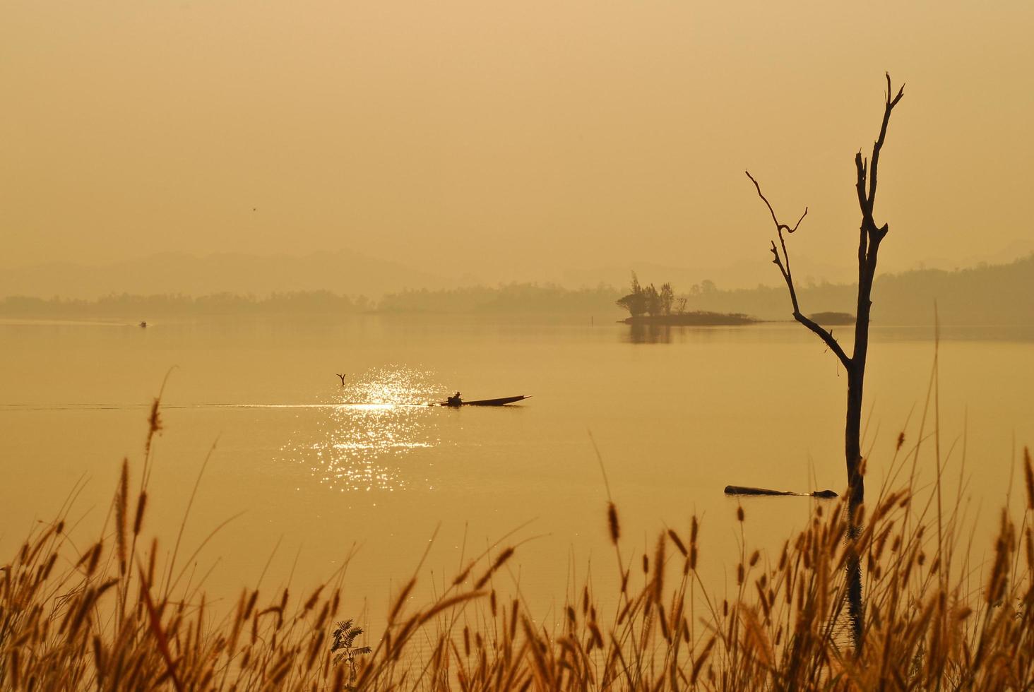 Beautiful view shadows Light Long-tailed boat sunrise in dam Srinakarin National park Kanchanaburi, Thailand photo