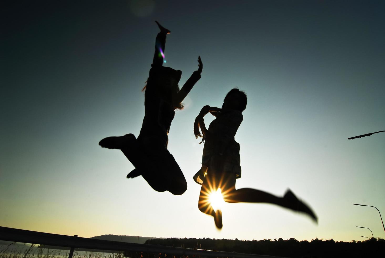 silueta mujer feliz saltando contra hermosa puesta de sol. libertad, concepto de disfrute. foto