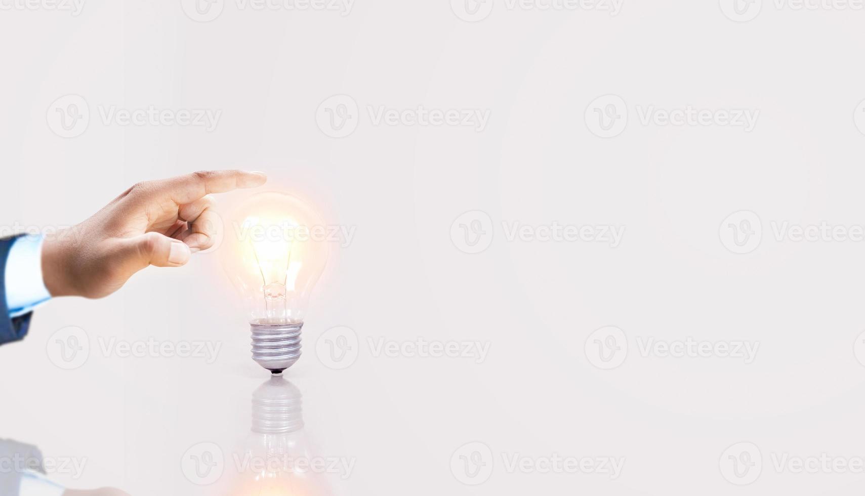 Hombre de negocios de la mano, finanzas y ahorro de energía, concepto de innovación e inspiración de electricidad de bombilla de mano. foto