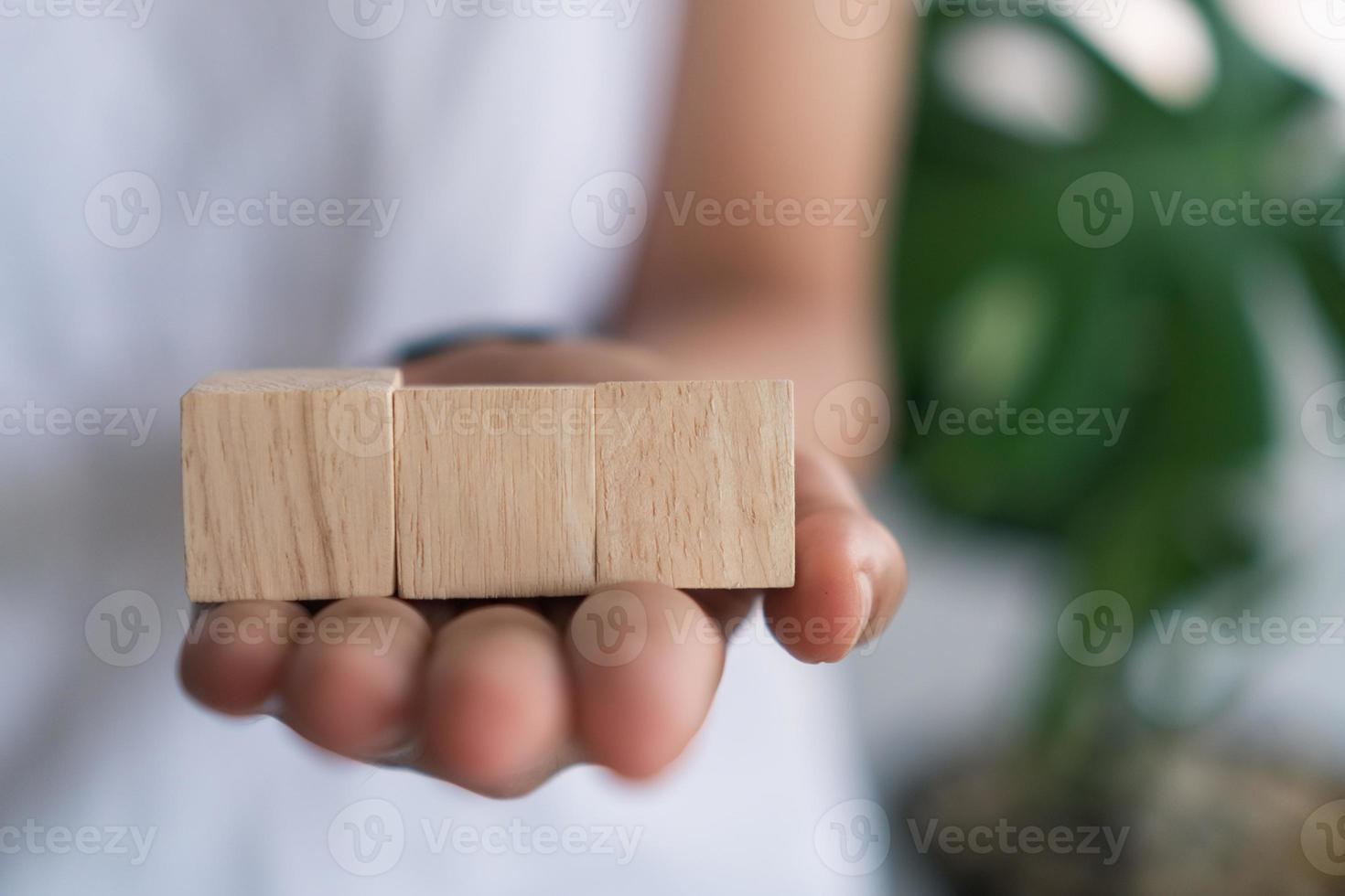 Cubo de madera en blanco en el que puede poner texto o icono en la sujeción de la mano. foto