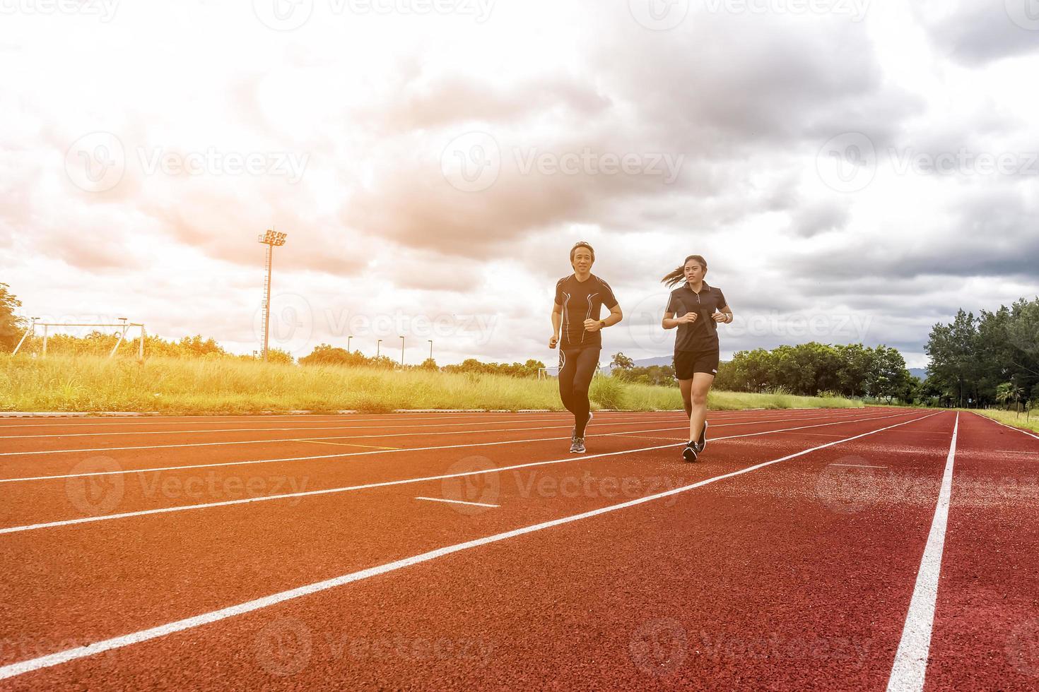 Dos corredores trotando en la pista de carreras, el deporte y el concepto de actividad social foto