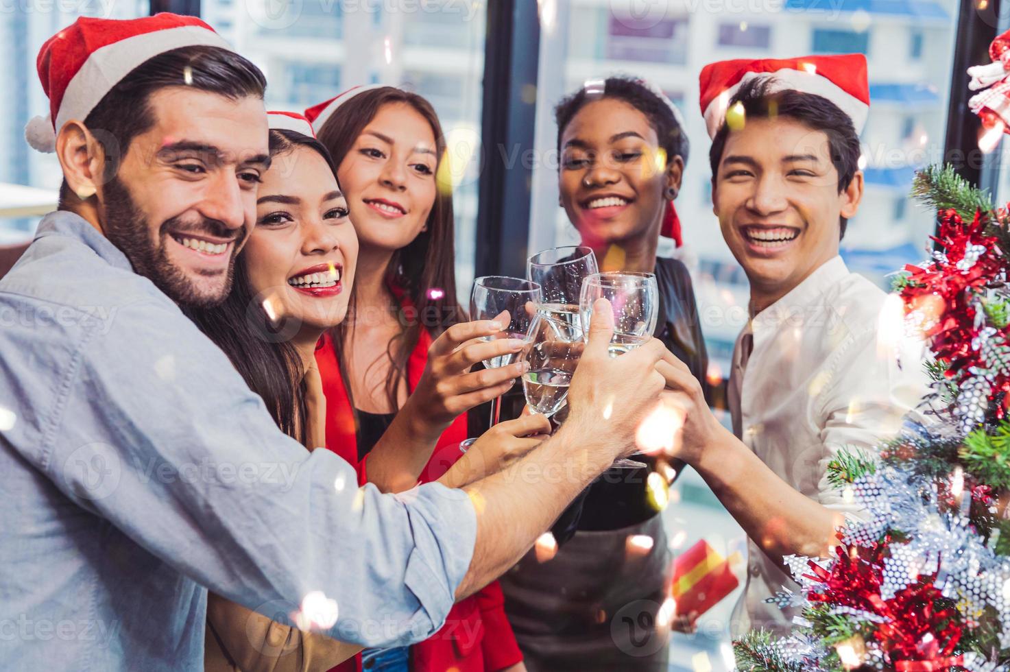 grupo de trabajo en equipo de colega de diversidad empresarial celebaring para la fiesta de año nuevo en el fondo de la oficina urbana moderna. amigos que disfrutan de la fiesta con alcoholivd beben juntos. estilo de vida de la gente de ética múltiple foto