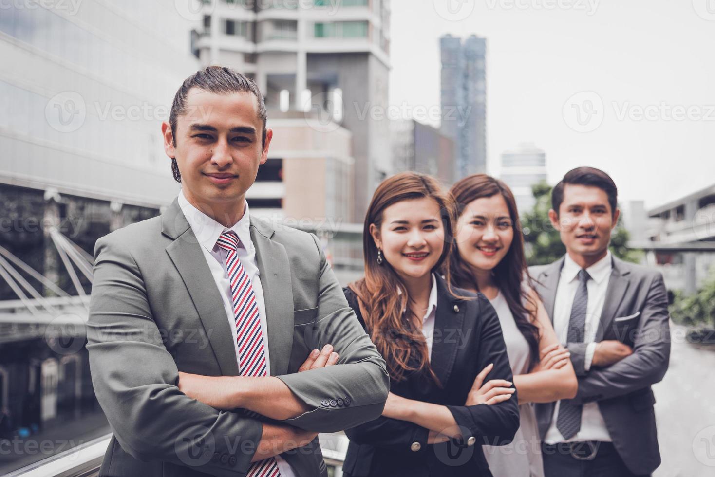 Equipo de gente de negocios haciendo retrato de gesto de confianza al aire libre en la ciudad. multiculturalismo de ocupación asiática y caucásica. feliz liderazgo profesional de negocios de trabajo en equipo en traje. mirando a la cámara foto