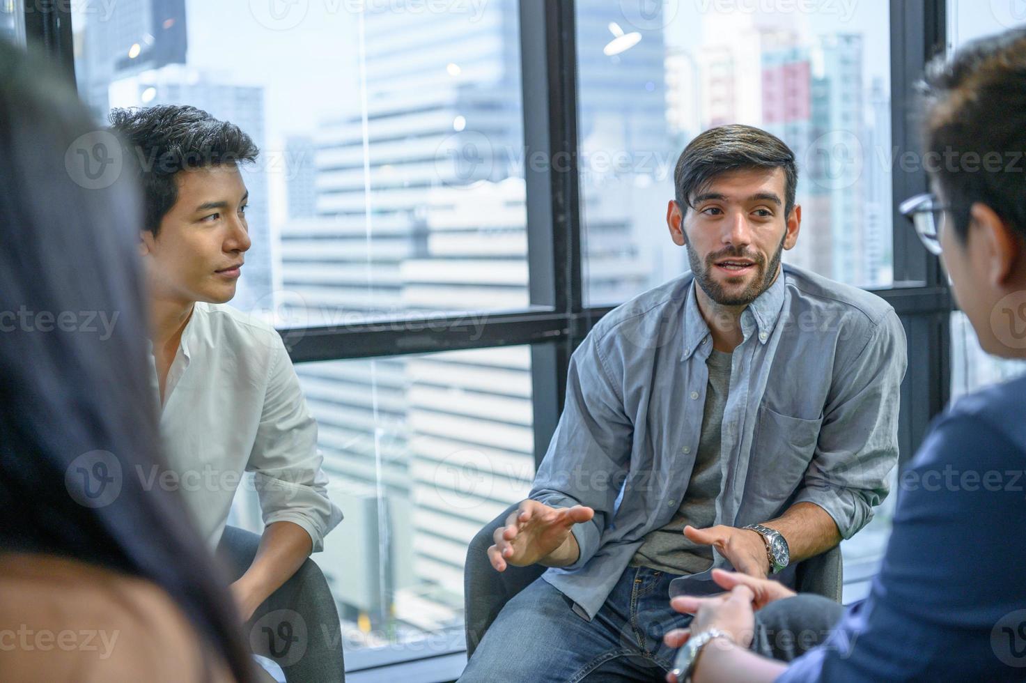 Psychotherapist inquiring about symptoms occurring within mind from patients with mental health problems in hospital. Group psychotherapy for support and helping worried man to change negative mindset photo