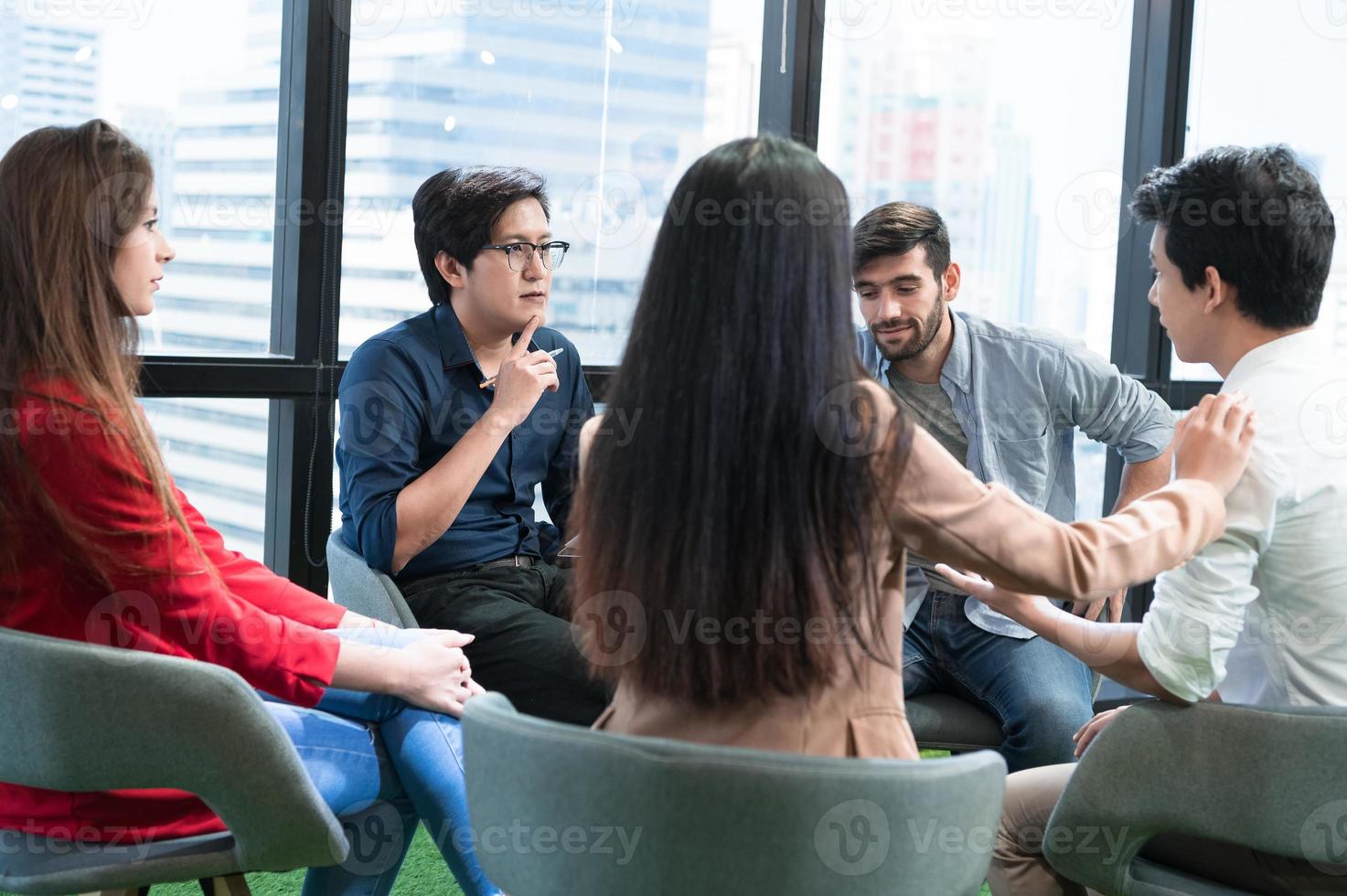 Psychotherapist inquiring about symptoms occurring within mind from patients with mental health problems in hospital. Group psychotherapy for support and helping worried man to change negative mindset photo