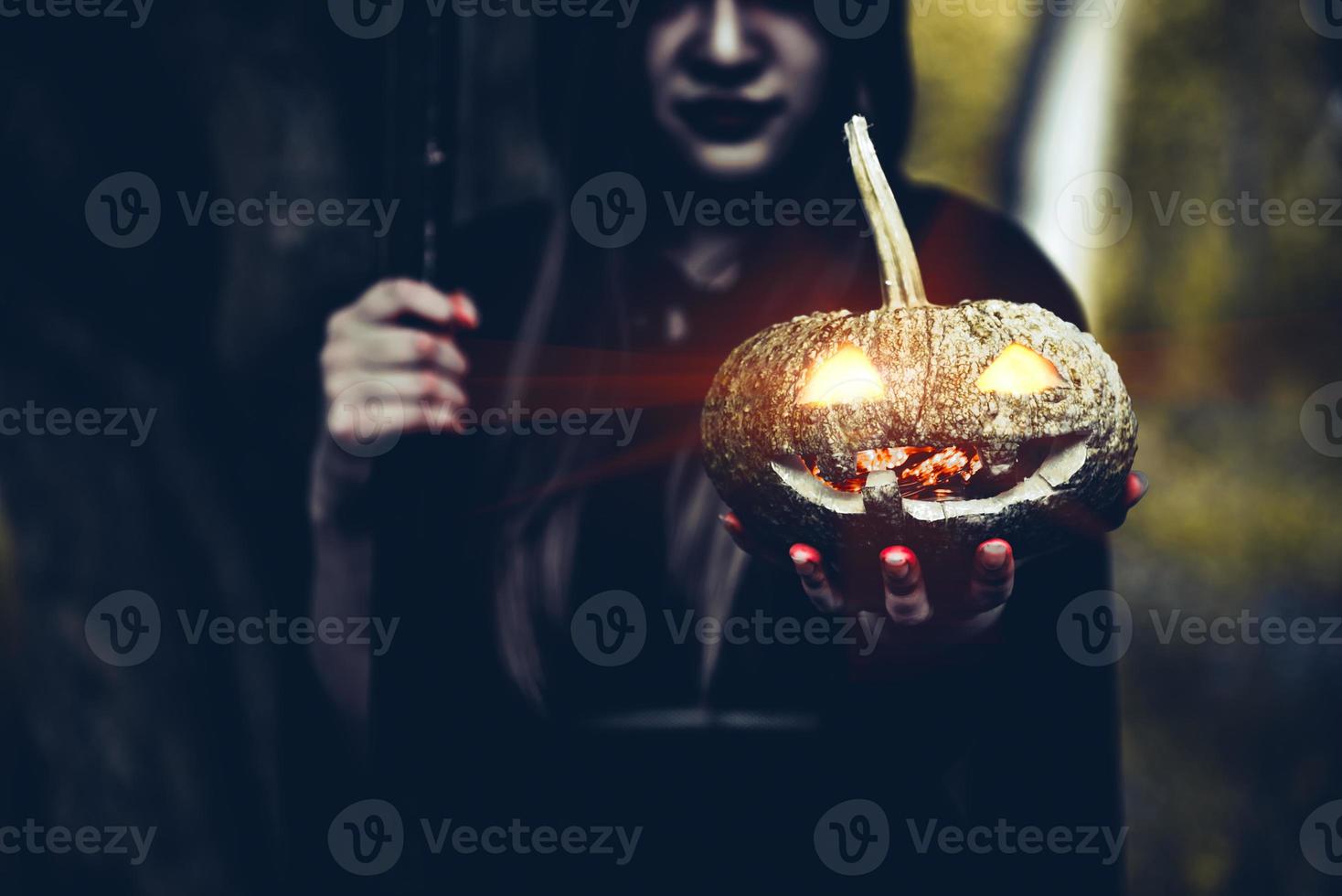 Pumpkin in witch hand. Old woman holding pumpkin in dark forest. Halloween day and Mystery concept. Fantasy of magic theme photo