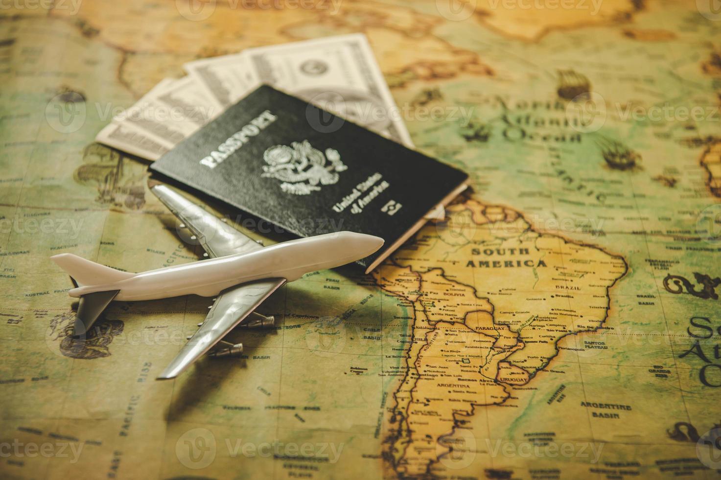 Top view of tourist planning props and travel accessories with American passport, airplane and US dollar banknote money on old grunge style map. Holiday and vacation. Tourism long weekend concept photo