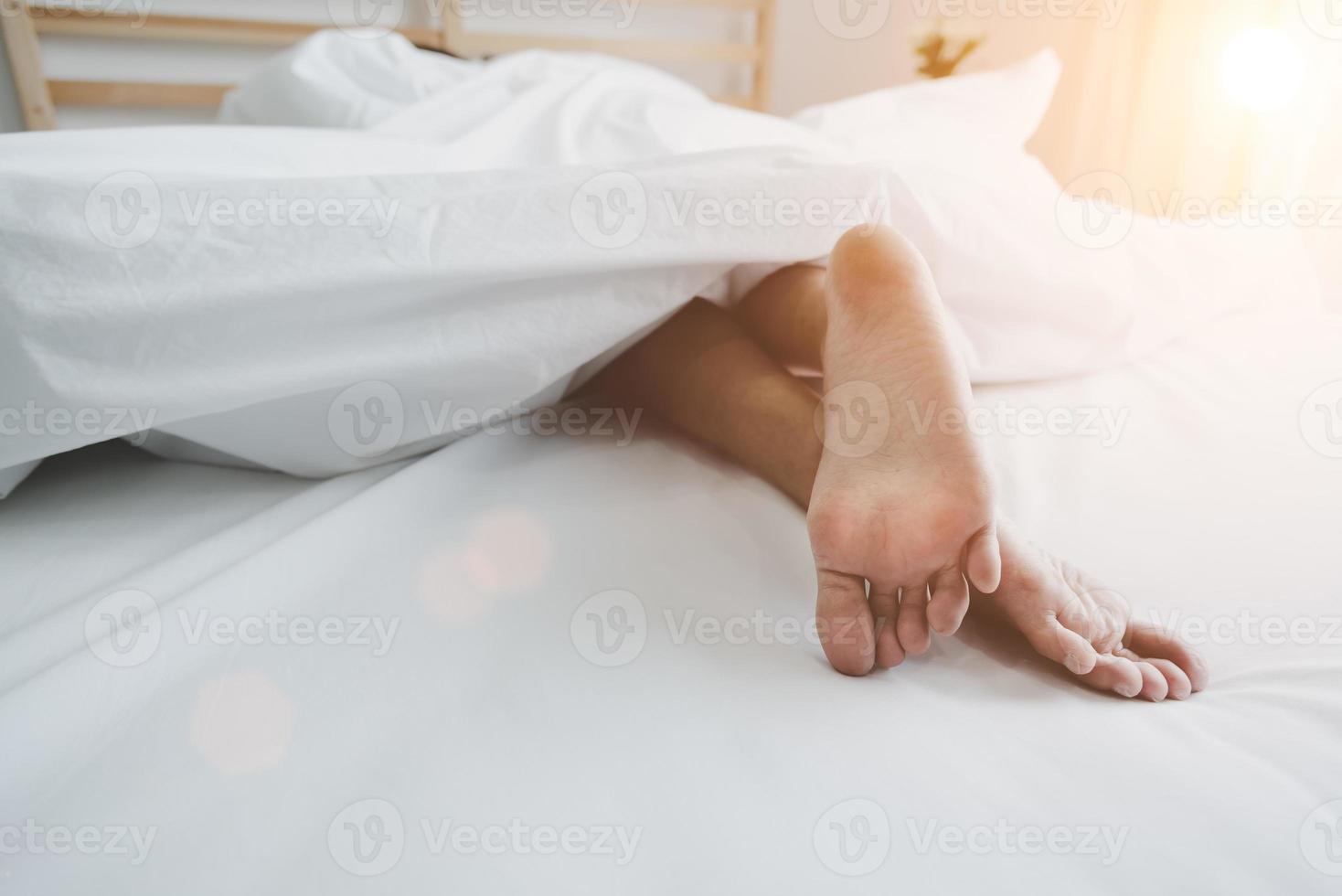 Barefoot of human on bed in morning. Single and Working people concept. Lazy day and Happiness home theme photo