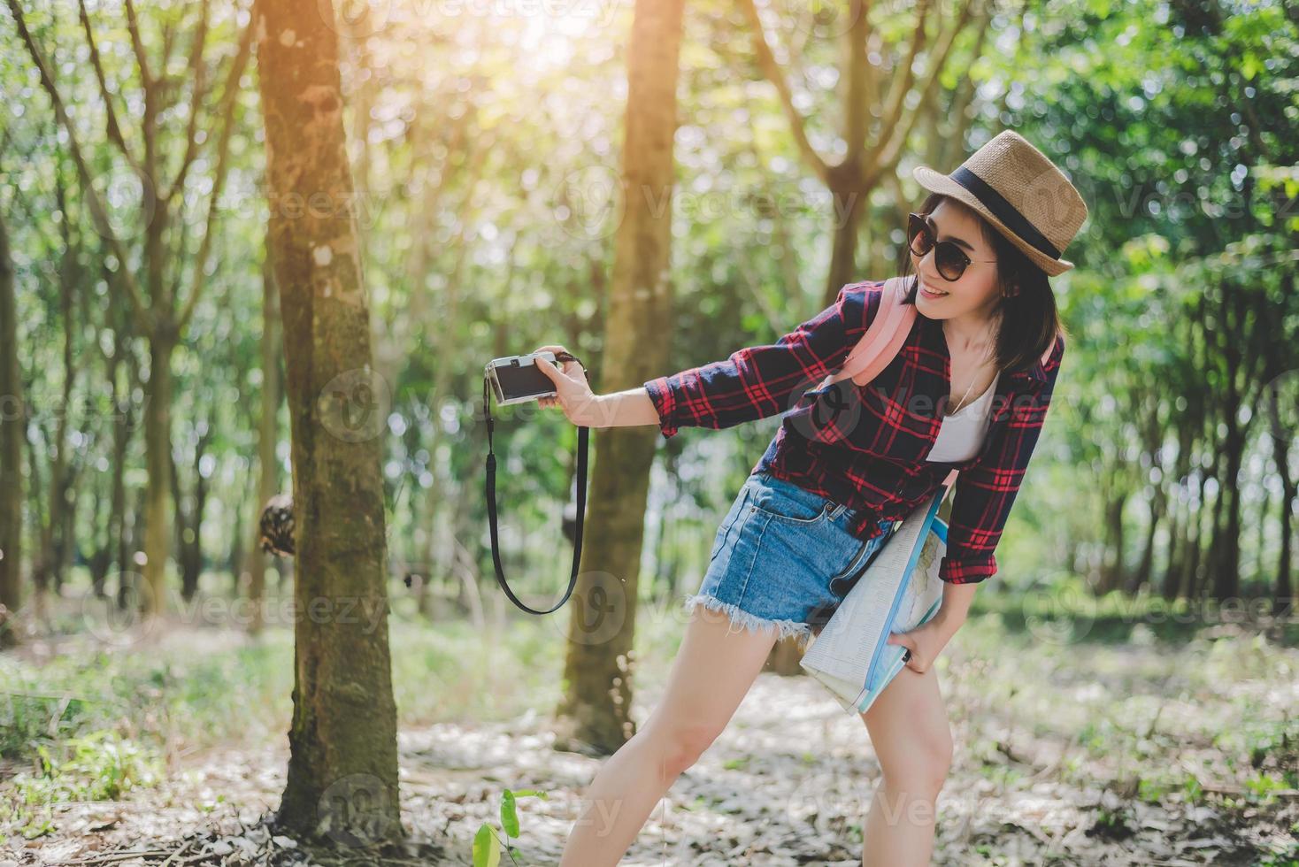 Beauty Asian woman smiling lifestyle portrait of pretty young woman having fun in outdoors summer with digital camera. Traveling of photographer concept. Hipster style and Solo woman theme photo