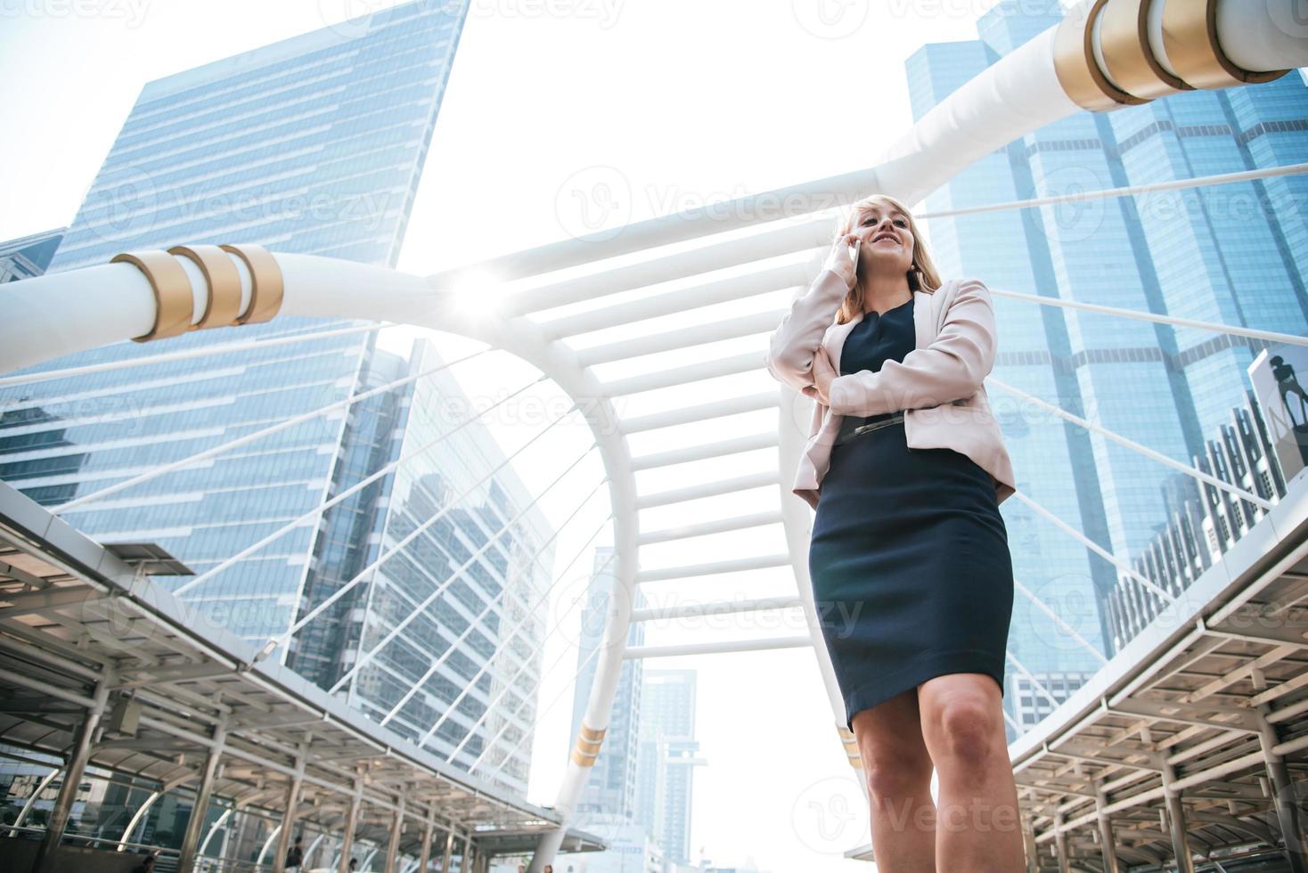 empresaria de belleza mediante teléfono móvil para comunicarse con los clientes de la ciudad. concepto de negocio y tecnología. tema de la metrópoli foto