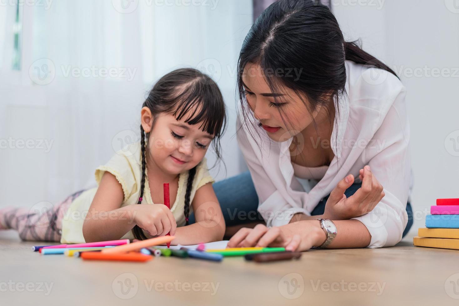 mamá enseñando a su hija a dibujar en la clase de arte. volver al concepto de escuela y educación. tema de niños y niños. tema hogar dulce hogar foto