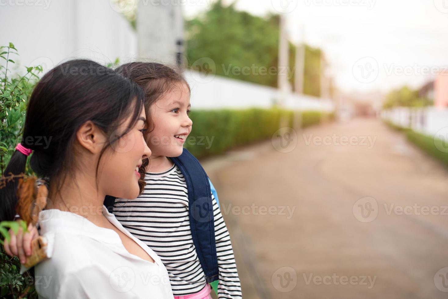 Mom and her daughter smiling together after going home from school. Love and daycare concept. Happy family and Home sweet home theme photo