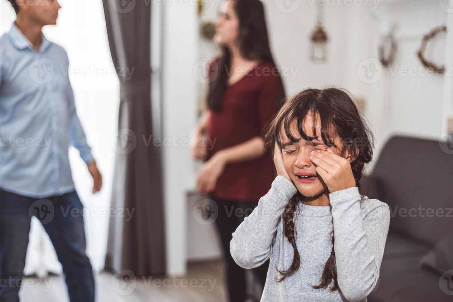 niña llorando porque sus padres se pelean. niña abusada con madre y padre gritando y conflicto de fondo enojado en casa. Escena dramática familiar, concepto de problema de problemas sociales familiares foto