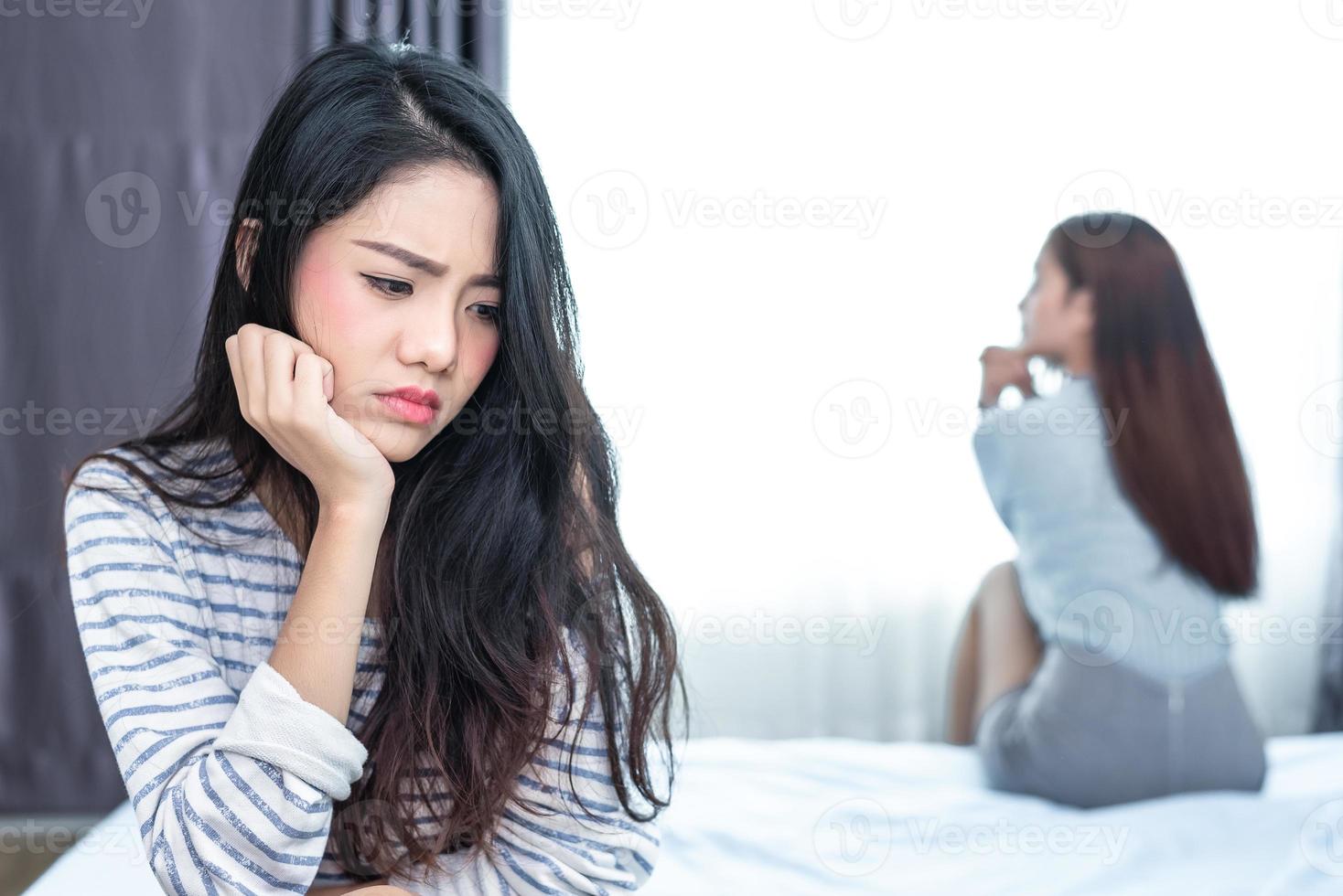 Married lesbian having stressed after conflict with lovers in bedroom. Serious and negative thinking people. Upset and unhappy female concept. Lifestyle and family issues concept photo