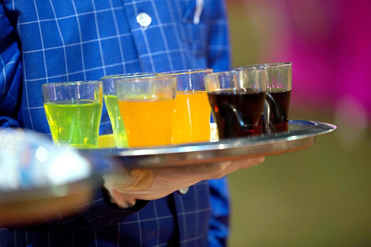 Cropped view of waiter is holding a tray and serving drinks photo