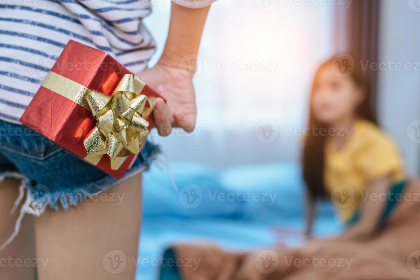 Close up of woman hands holding gift for surprise her girlfriend in bedroom. Person and people concept. Lifestyles and Happiness life concept. Lesbian and homosexual theme photo