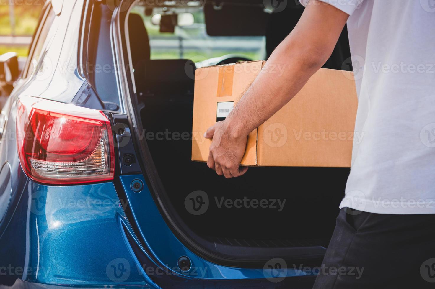 Delivery man is delivering cardboard box to customers photo
