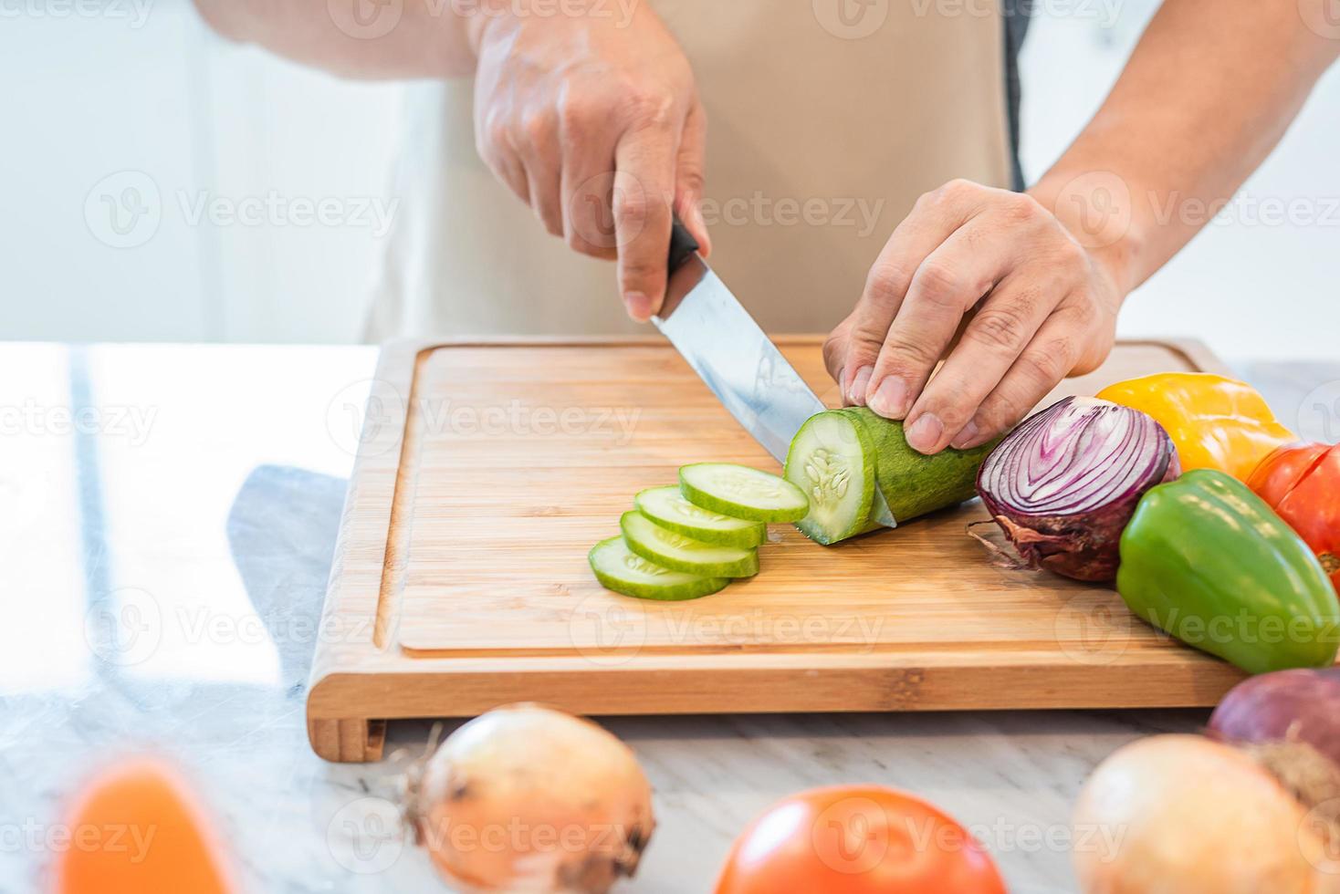 Close up of man hand cooking and slicing vegetable in the kitchen photo