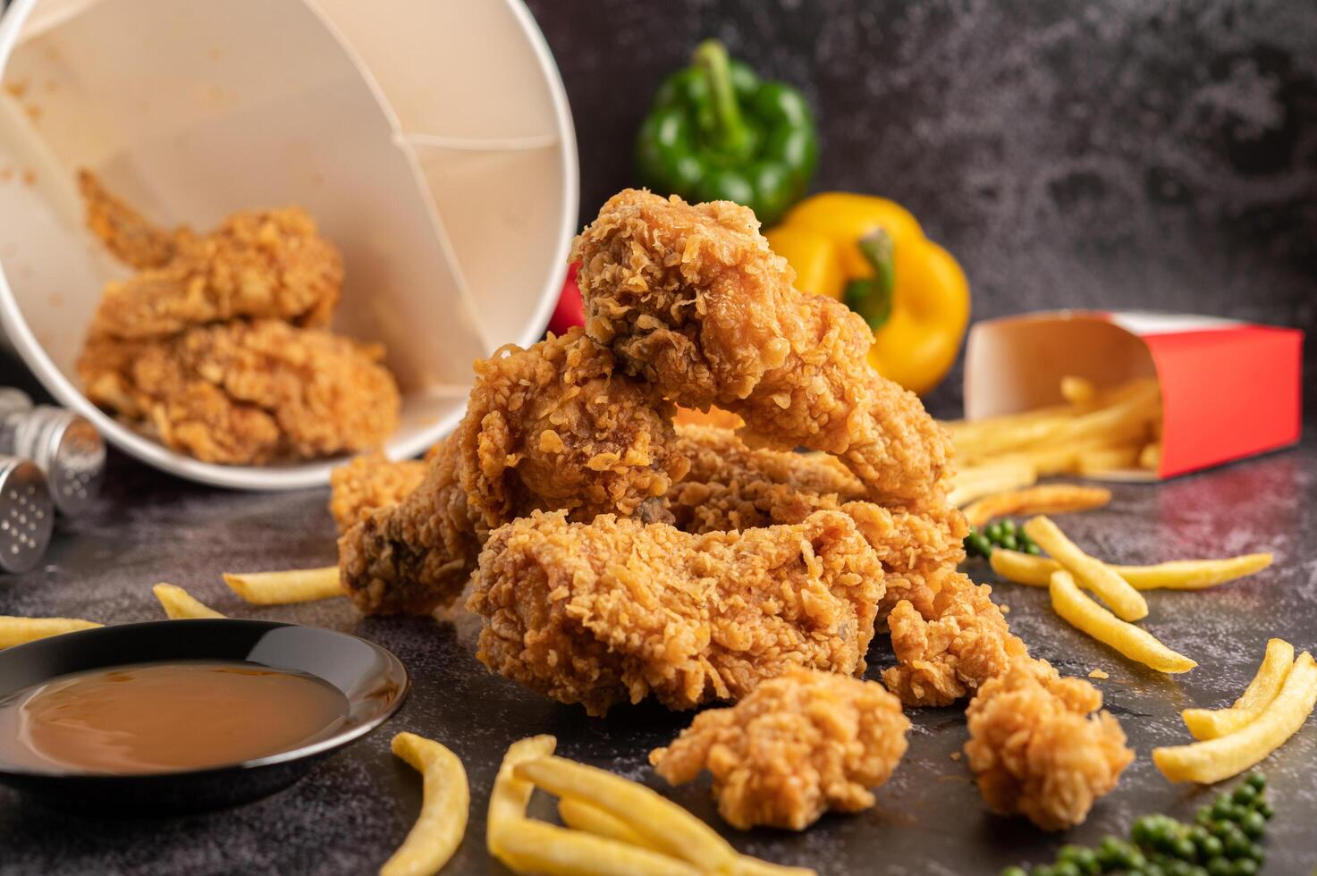 Fried Chicken and French Fries on Black Cement Floor. photo
