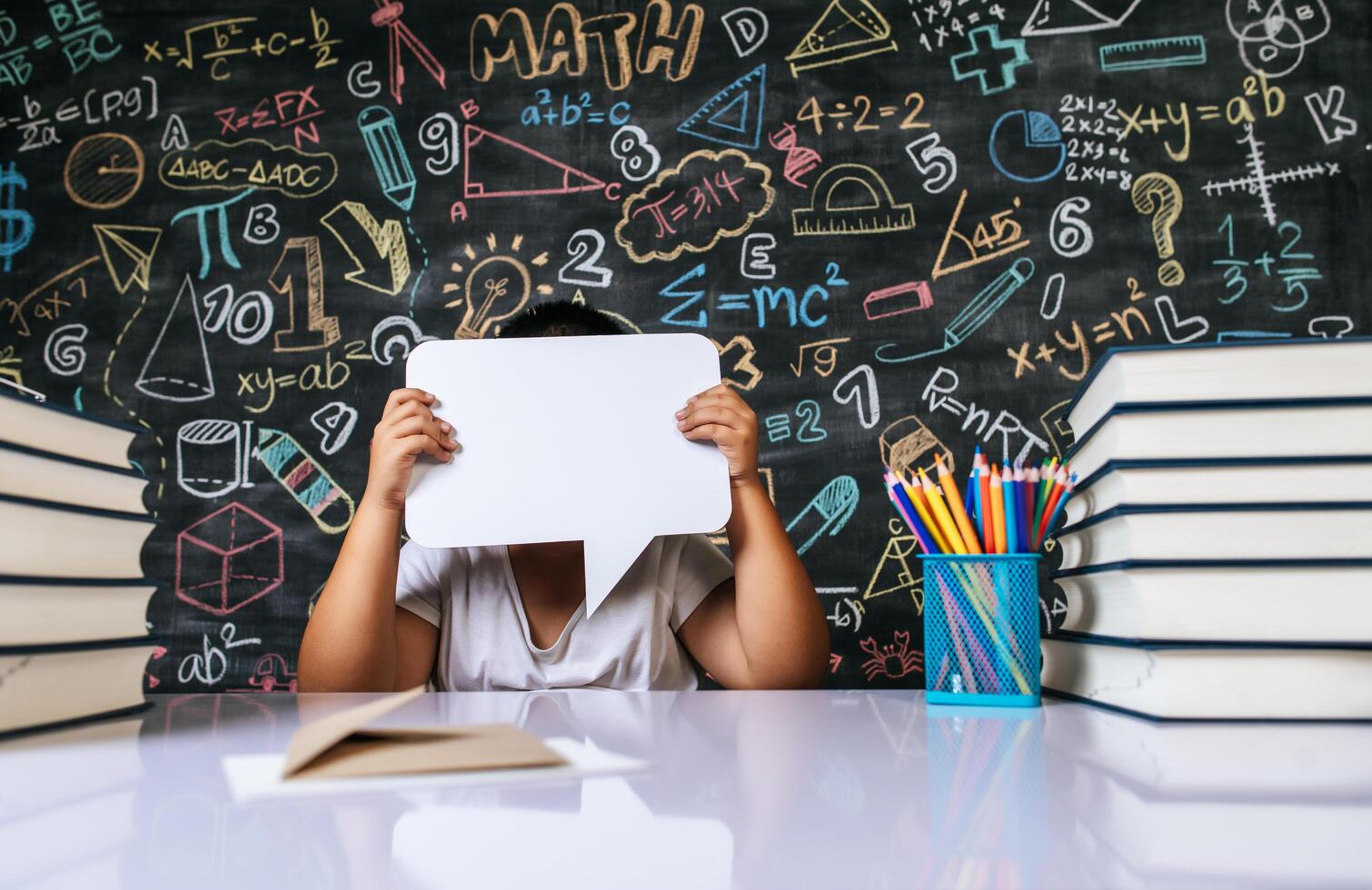 Child acting with speech bubble in the classroom photo