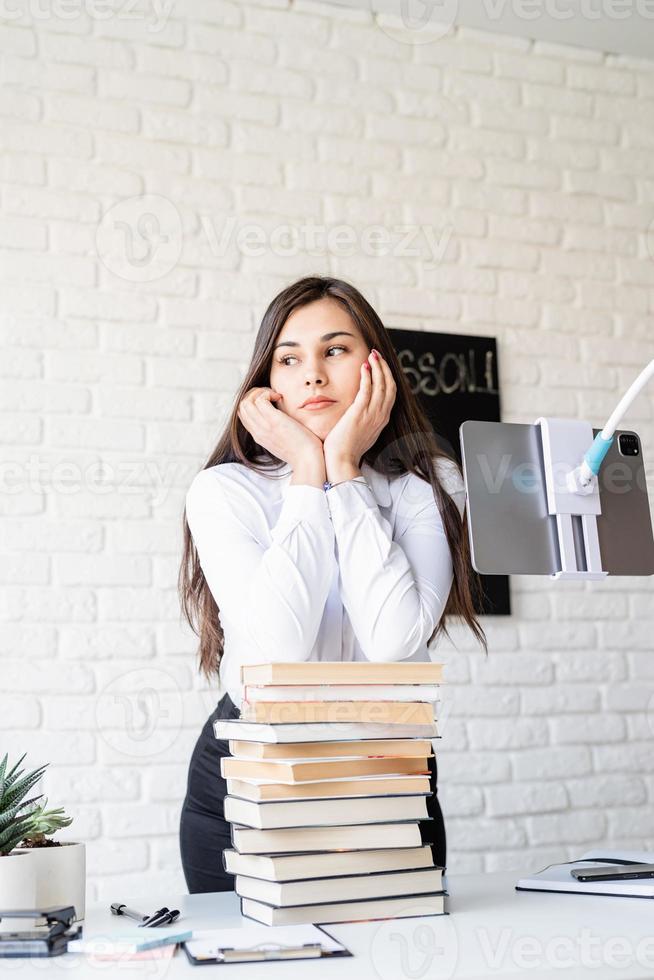 teacher with pile of books looking away ready for lesson photo