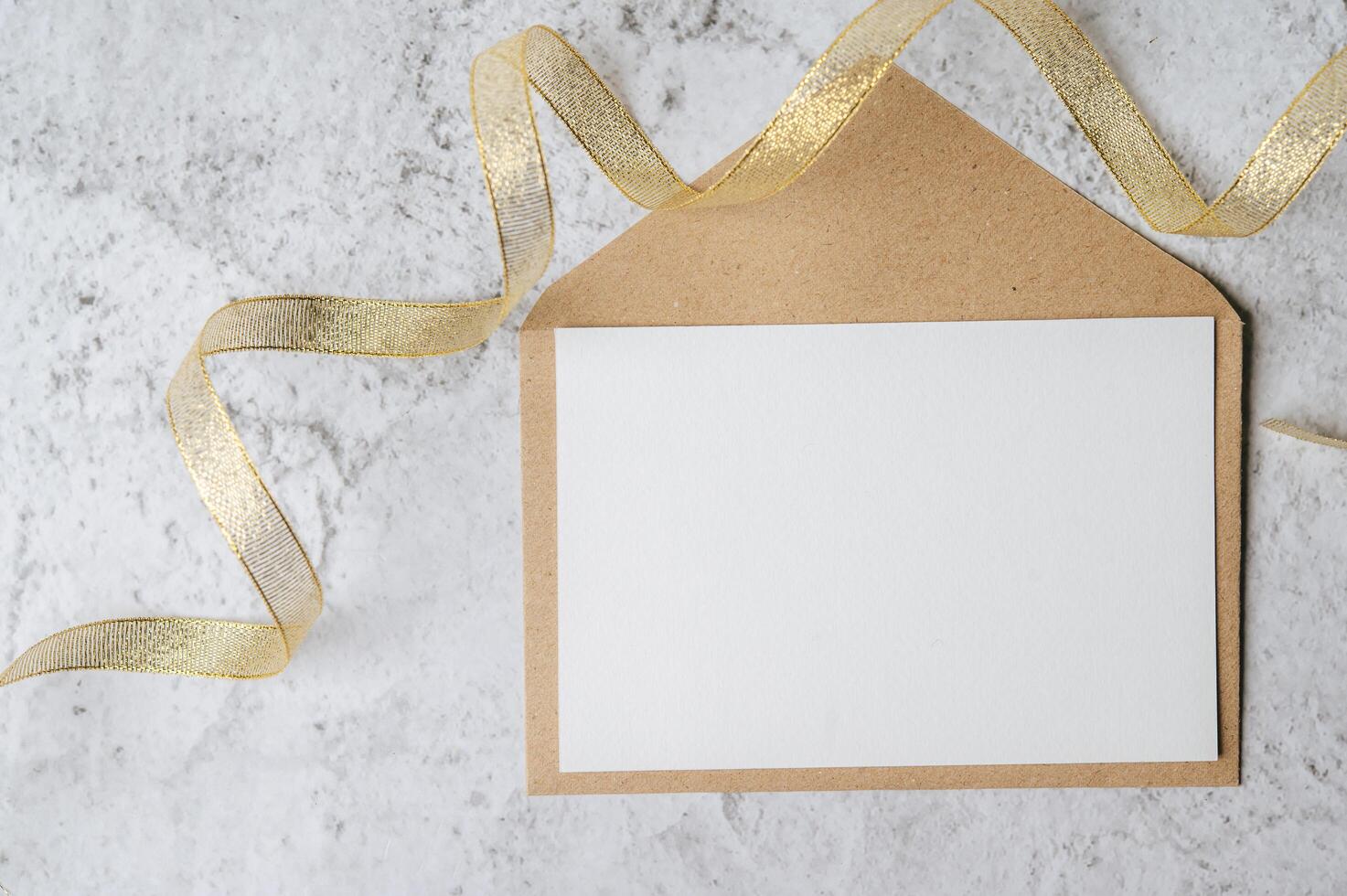 A blank card with envelope and leaf is placed on white background photo