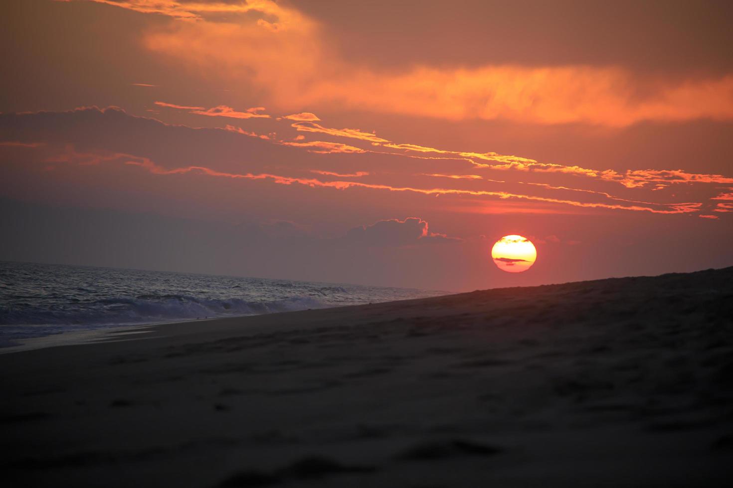 hermosa puesta de sol en la playa cerca del mar foto