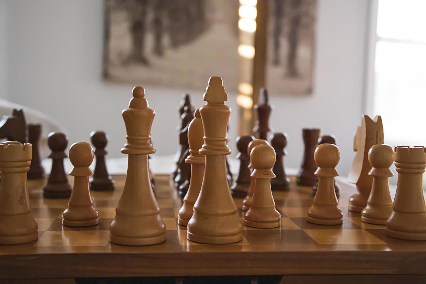 Closeup of wooden chess pieces on a wooden chess board photo