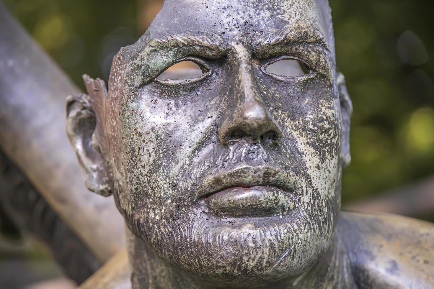 Broken face on a statue in a park, ancient sculpture in Thailand photo