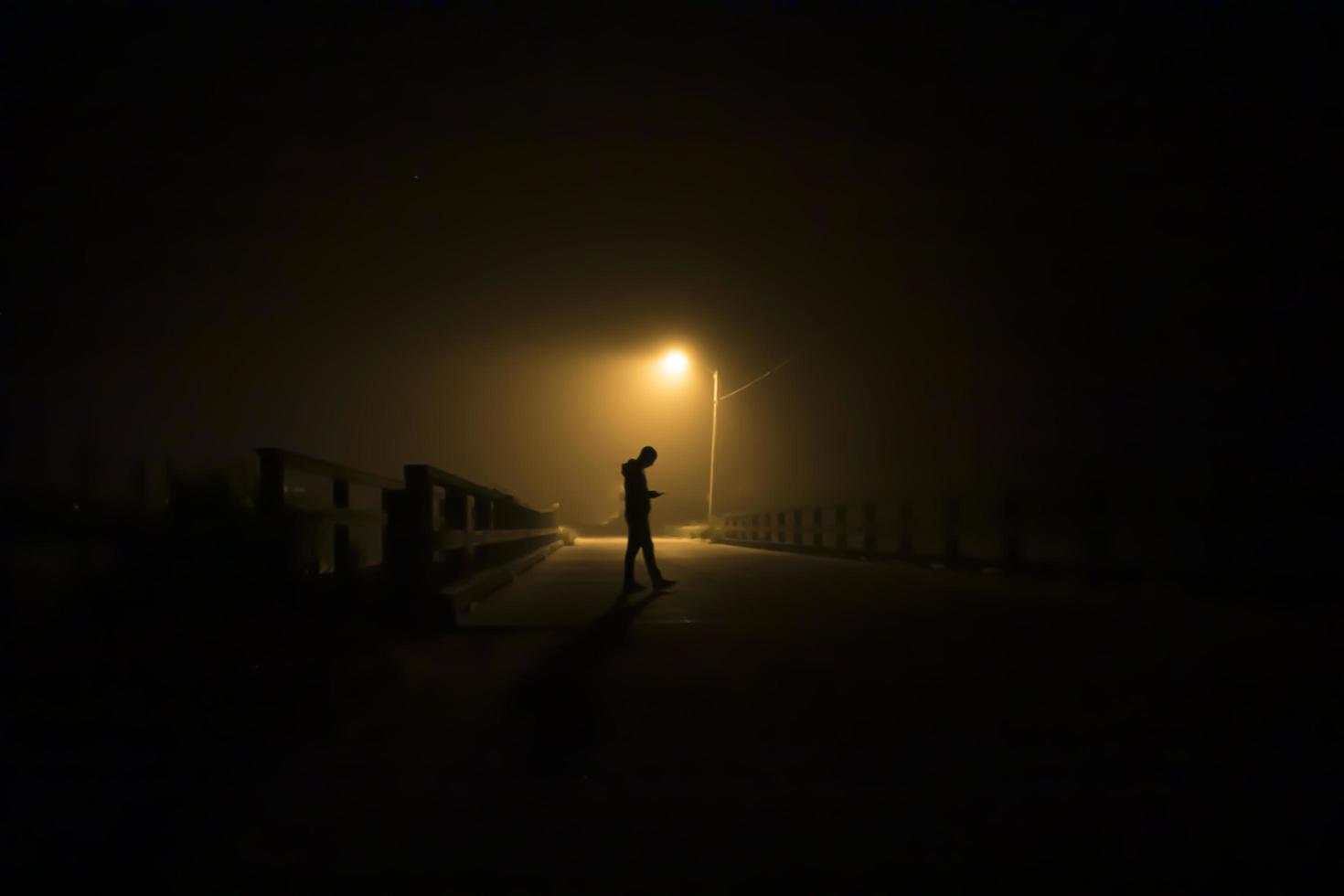 Silhouette of a man under a street light photo