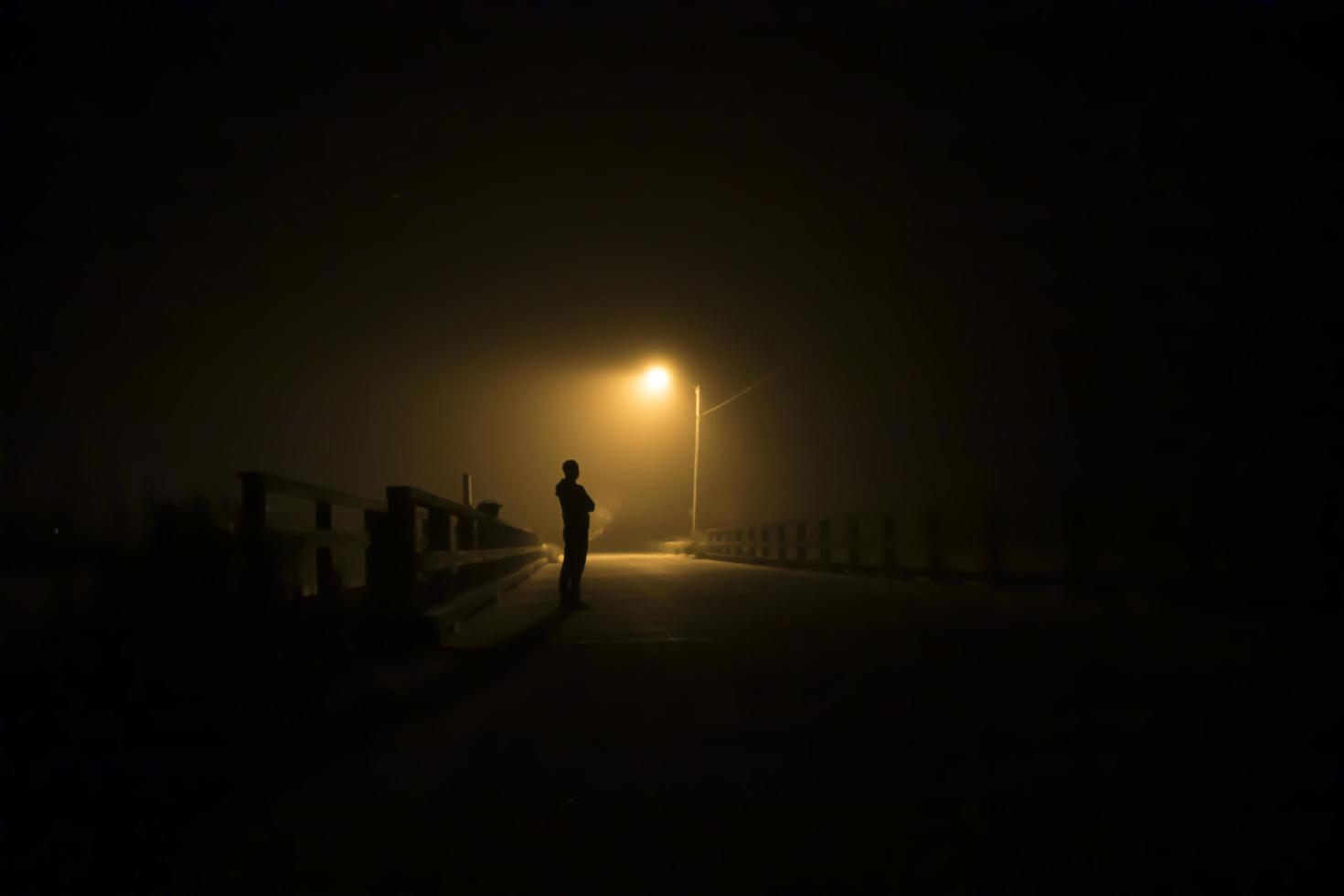 Silhouette of a man under a street light photo