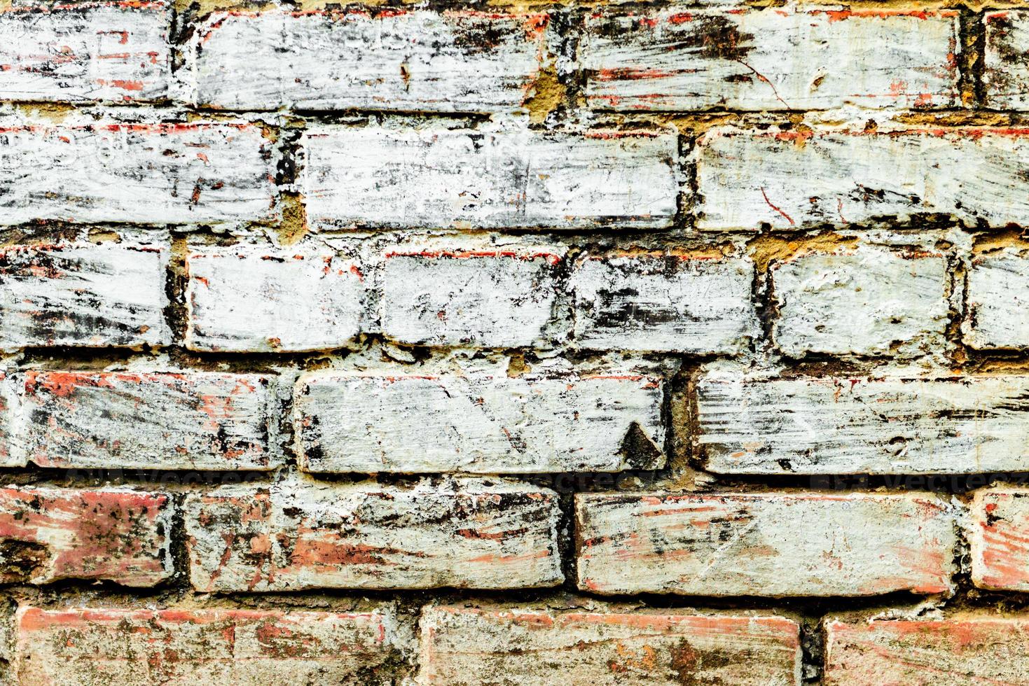 Textura de una pared de ladrillos con grietas y arañazos foto