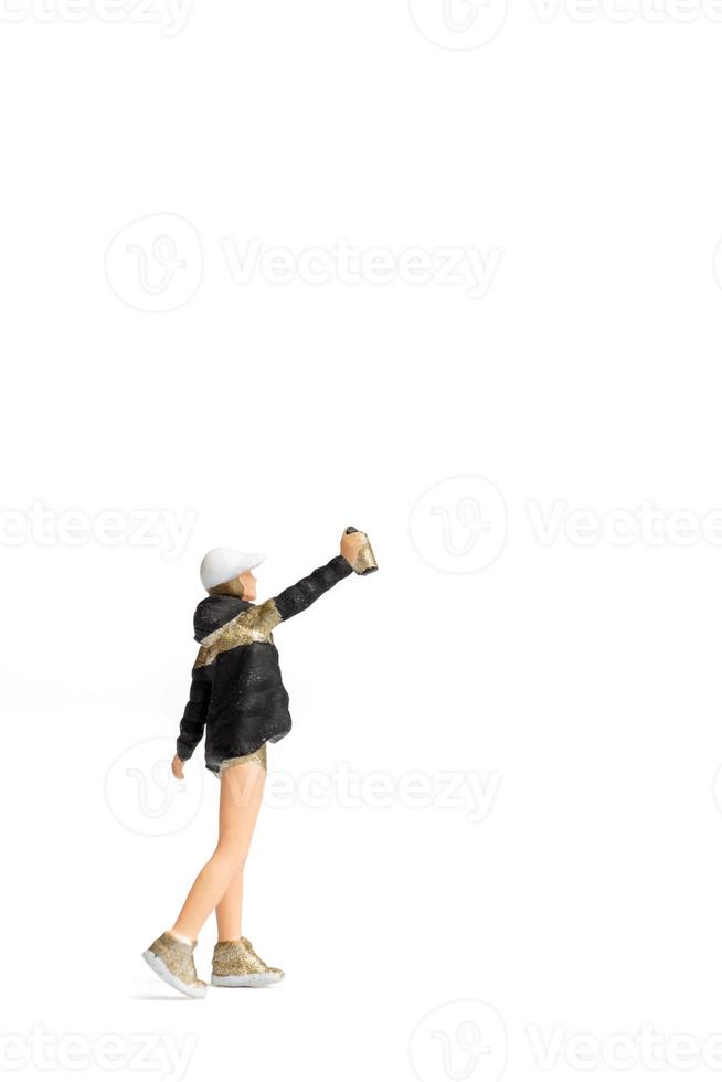 Miniature people Teenager spraying paint from can on white background photo